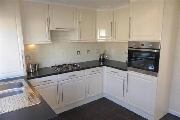Modern fitted park home kitchen with cream units and dark worktop